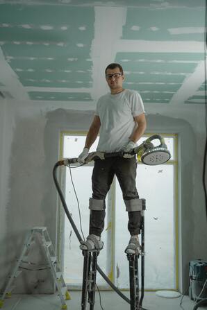 A painter standing on work stilts.